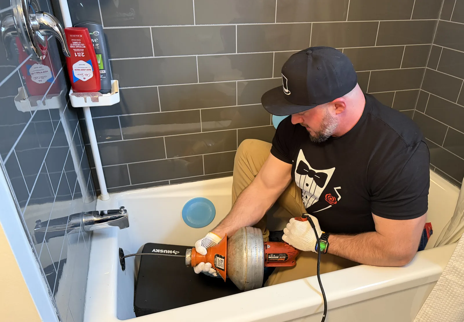 Gentlemen Plumbing plumber using drain equipment in a bathtub in Ottawa.