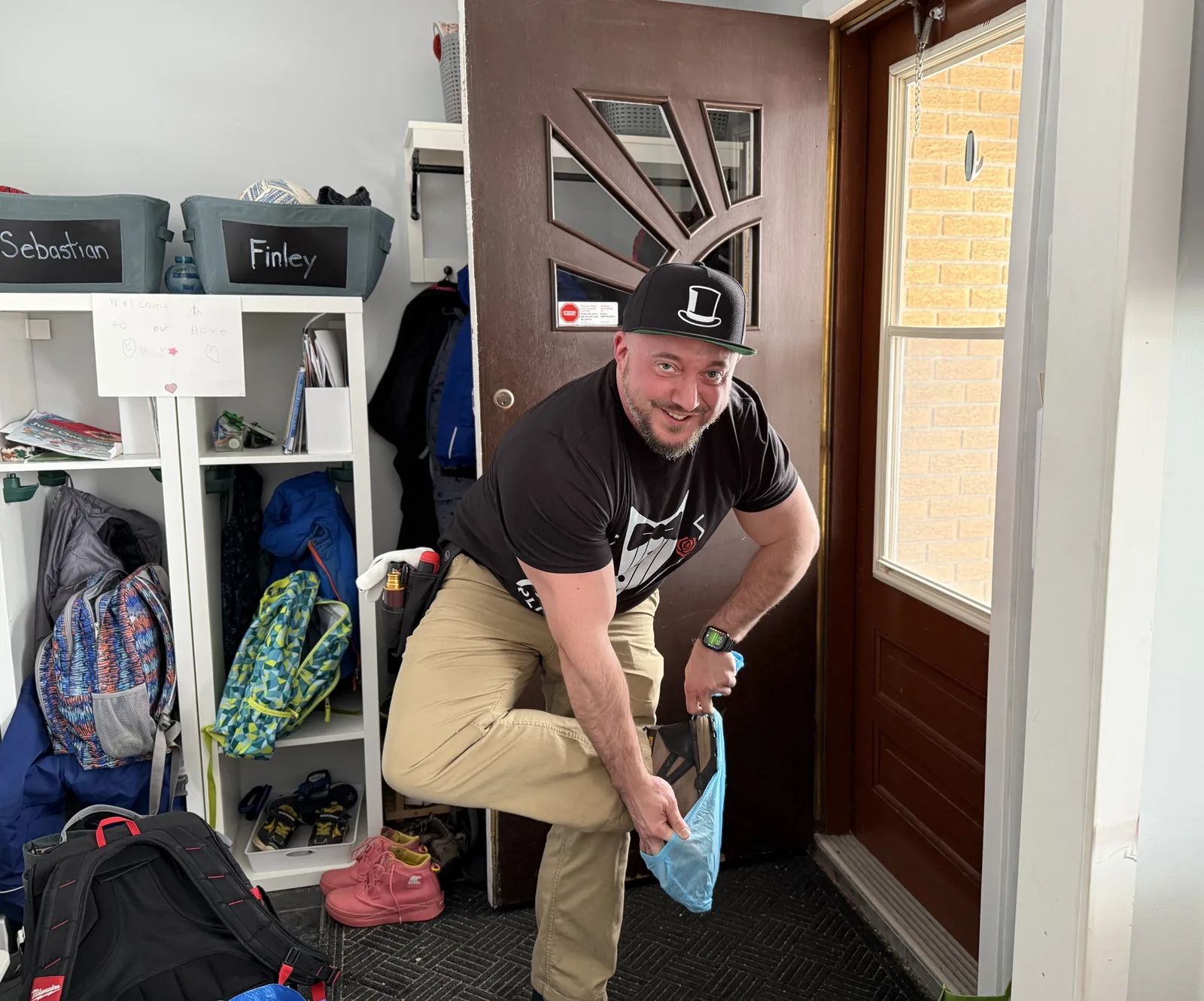 Plumber putting on shoe covers at an entryway.