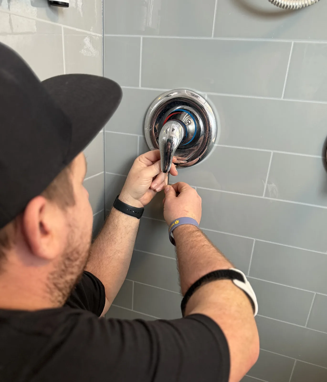 Gentlemen Plumbing plumber repairing a shower handle close up.