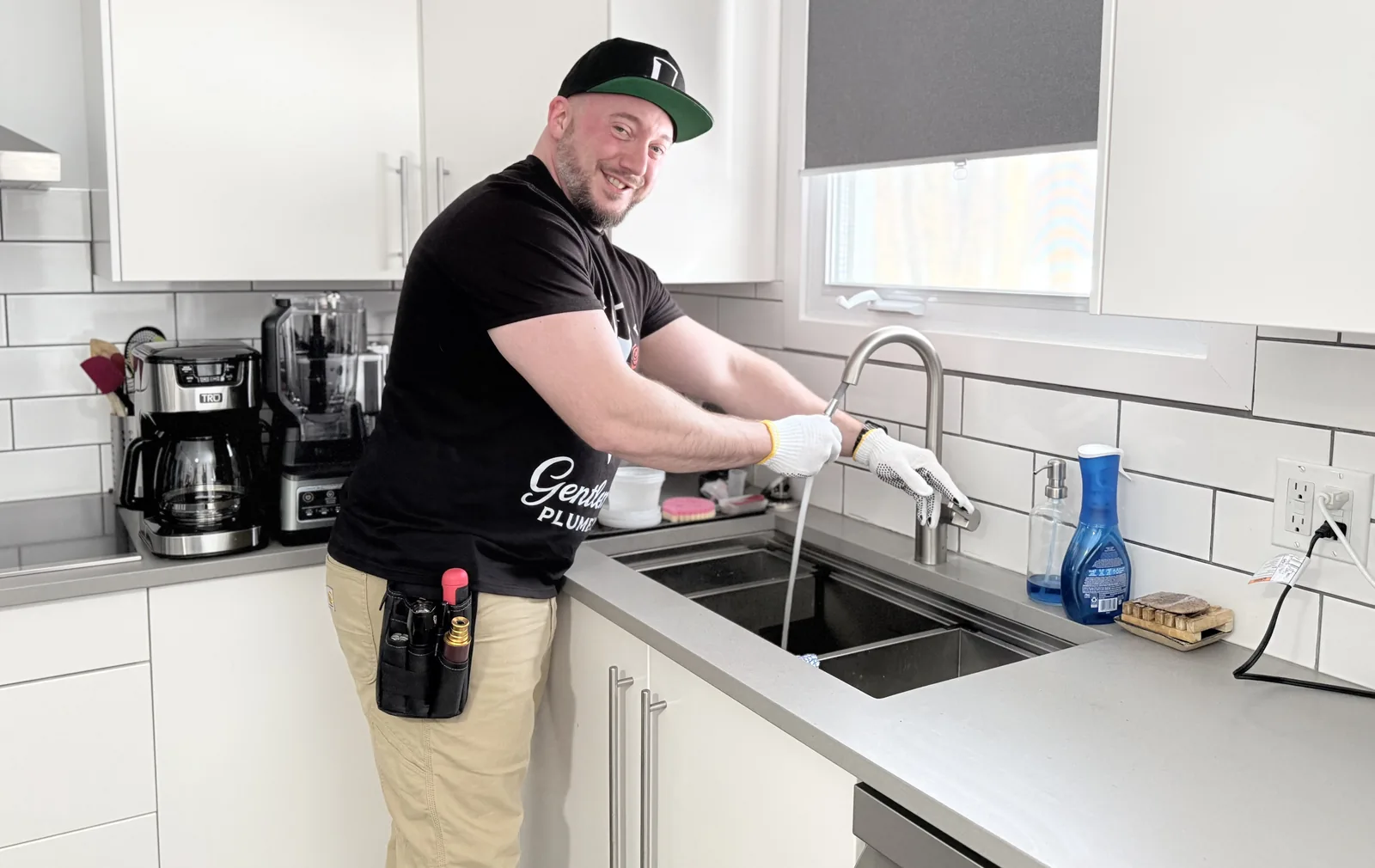 Gentlemen Plumbing technician testing a kitchen faucet at the sink.
