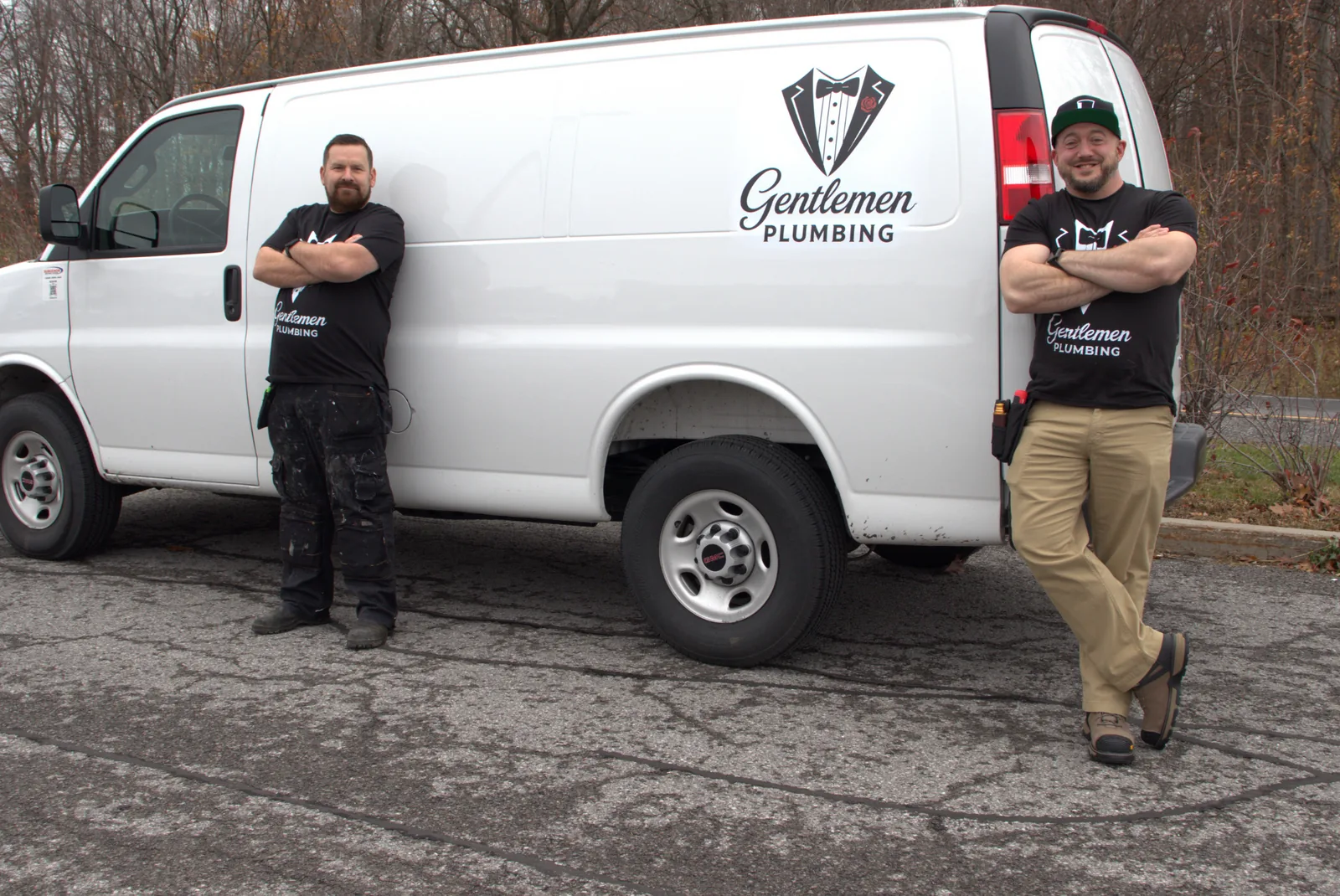 Two Gentlemen Plumbing technicians standing beside the full branded service van.