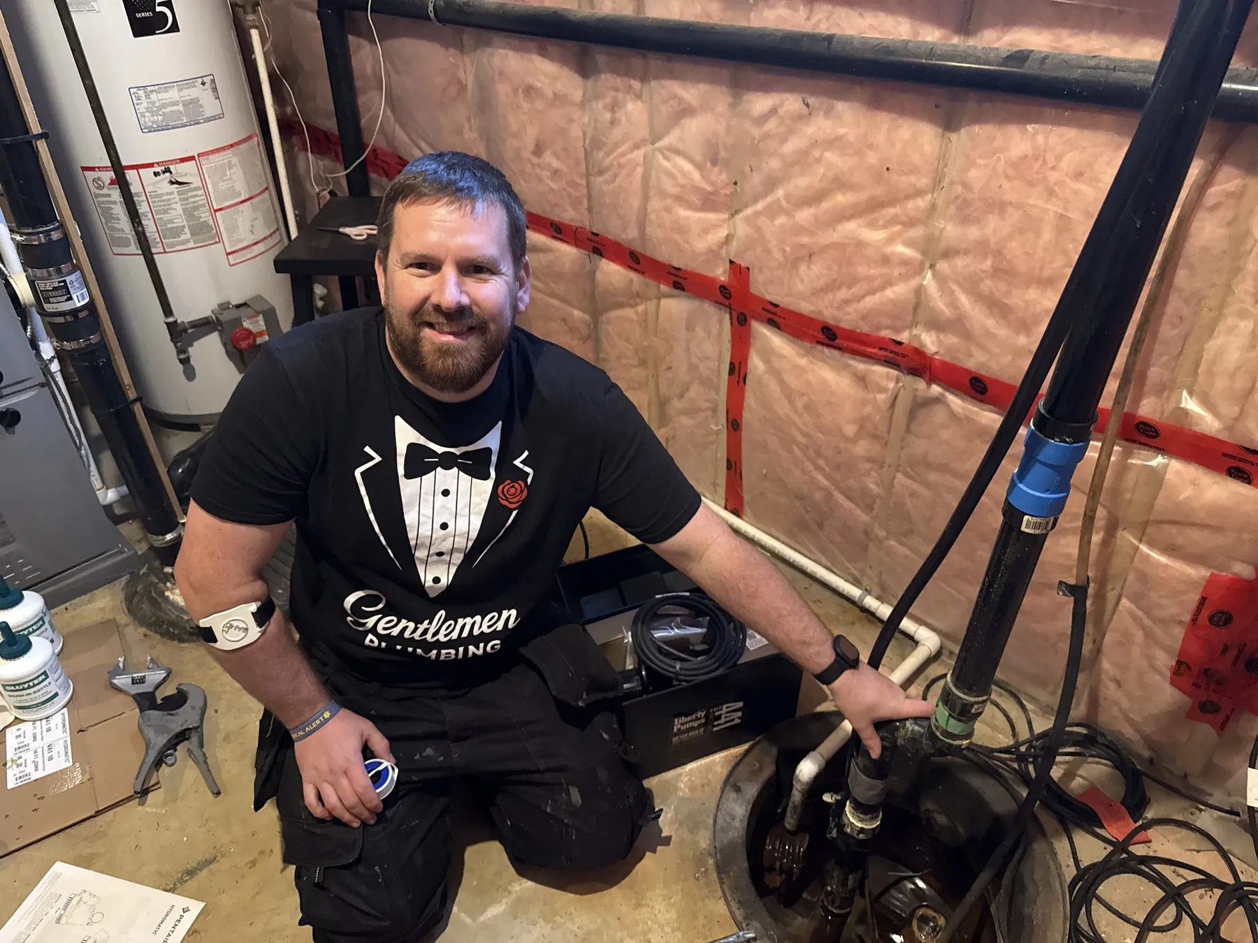 Plumber inspecting sump pump battery backup equipment in Ottawa.