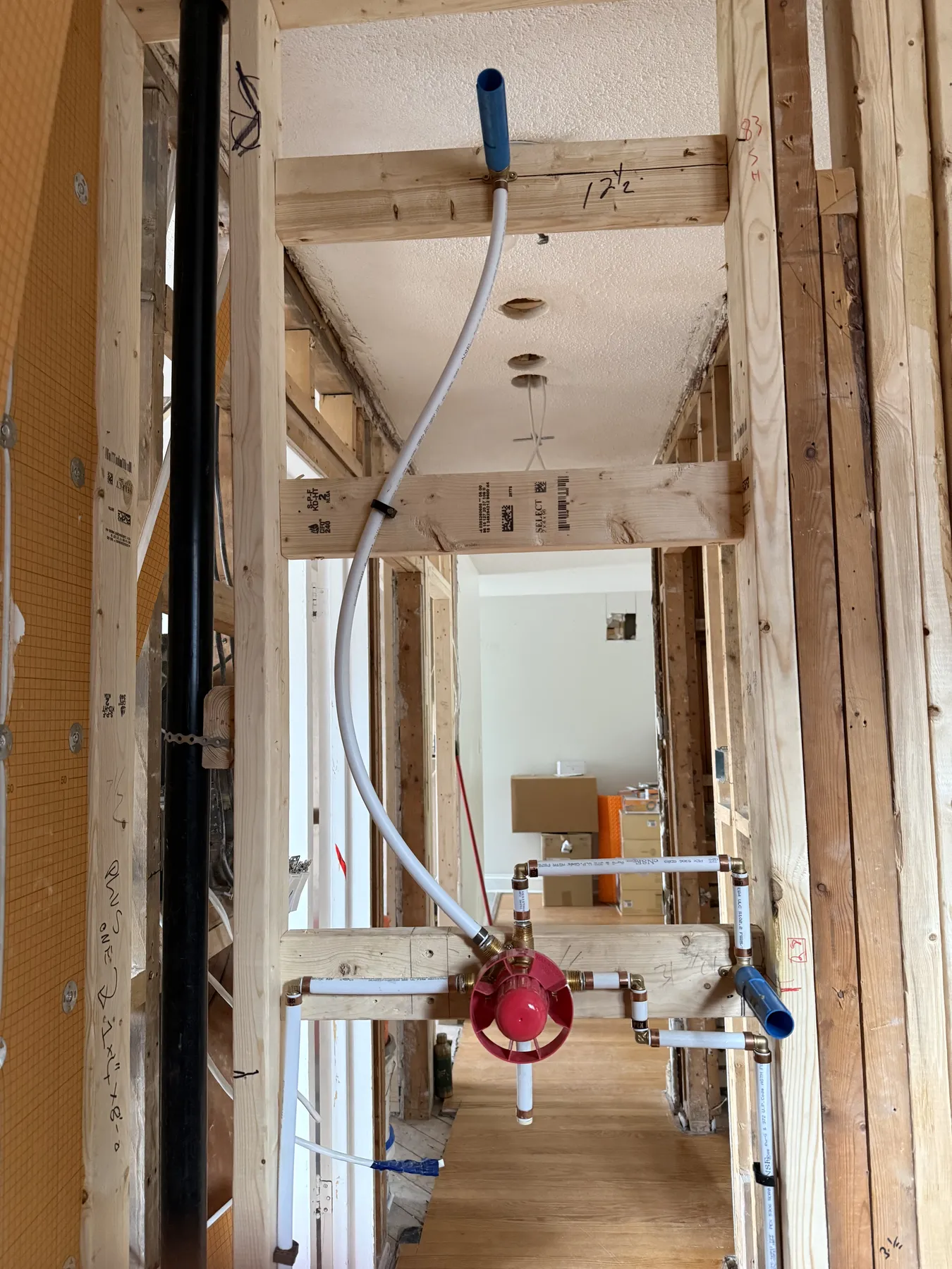 Close-up of shower valve rough-in with white PEX waterlines during an Ottawa bathroom renovation.