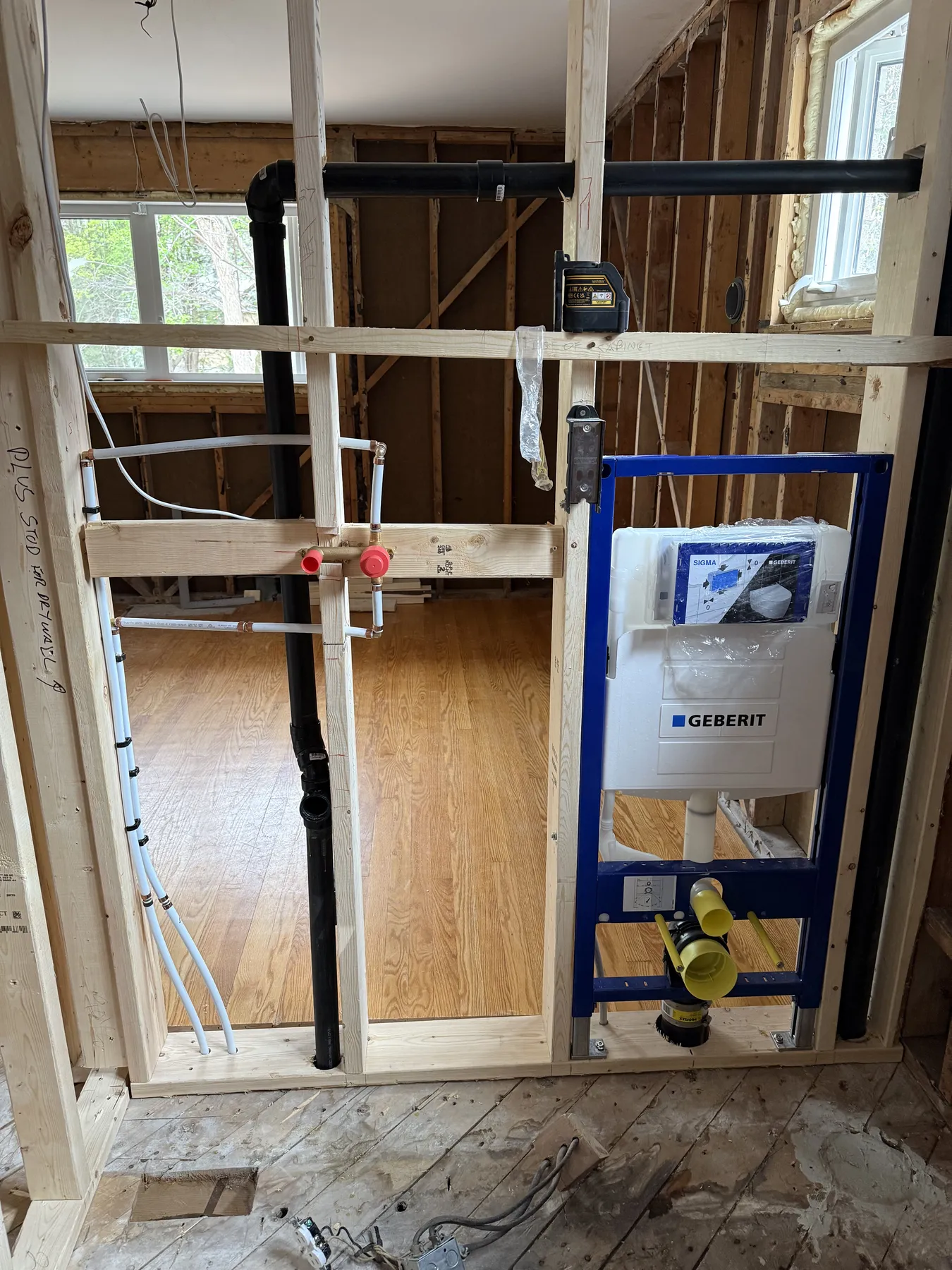 Wide bathroom renovation rough-in overview with Geberit carrier, ABS DWV piping, and PEX waterlines.