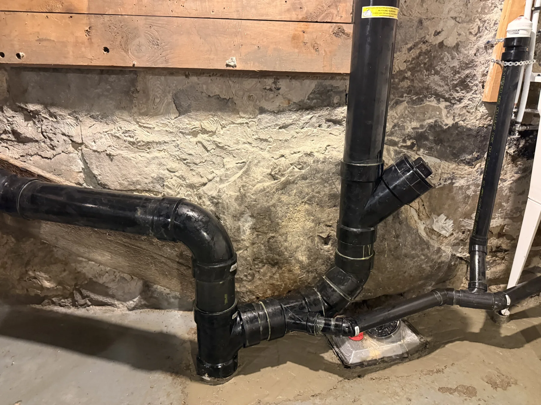 ABS basement drain installation and backwater valve context showing lower-level drain piping.